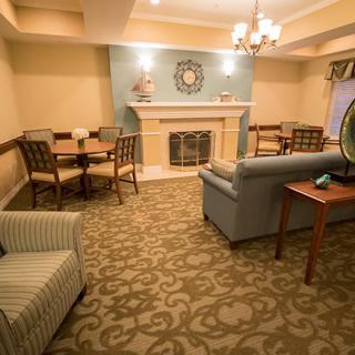 A cozy living room with a fireplace and modern decor, featuring comfortable seating and a chandelier.