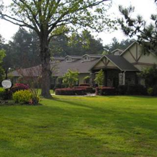 A charming house with a well-maintained garden and lush green lawn.