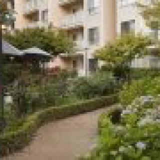 A beautifully landscaped garden path in front of an apartment building.