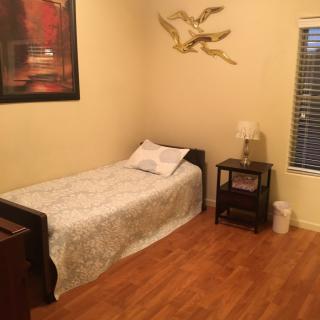 A cozy bedroom with a single bed, nightstand, and decorative elements.