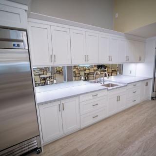 A modern kitchen with sleek white cabinets and stainless steel appliances.