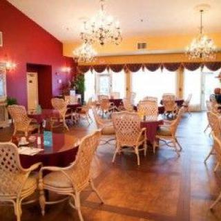 A cozy and elegant dining area with wicker chairs and chandeliers.