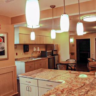 A modern kitchen interior featuring elegant lighting and granite countertops.