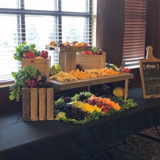 A beautifully arranged buffet display of fresh fruits and vegetables.