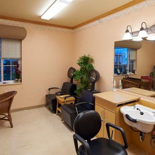 A cozy salon interior with styling chairs, mirrors, and a washing sink.