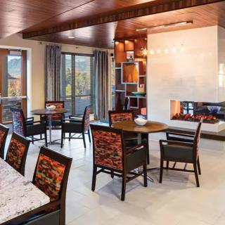 A modern dining area with a cozy fireplace and wooden furniture.
