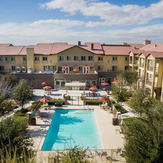A scenic view of a resort with a swimming pool and lounge area.