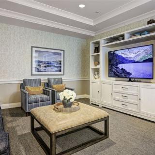 A cozy living room with a television, comfortable seating, and stylish decor.