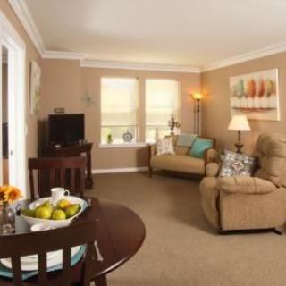 A cozy living room with a sofa, television, and a dining table.