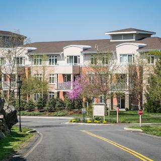 A modern residential complex surrounded by greenery on a sunny day.