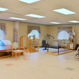 A rehabilitation therapy room equipped with various exercise and therapy equipment.