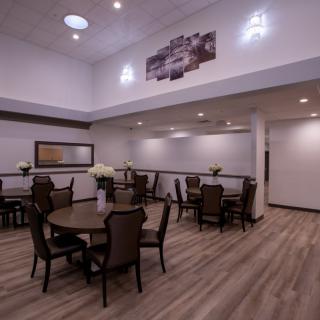 A modern dining area with multiple tables and chairs, featuring elegant lighting and decor.
