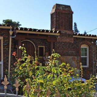 A charming brick house with a chimney and garden.