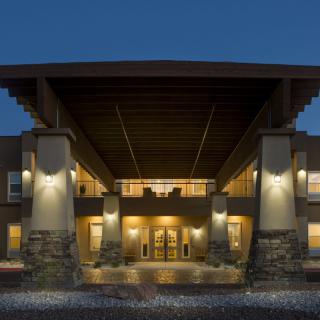 Illuminated building entrance at night with modern architectural design.