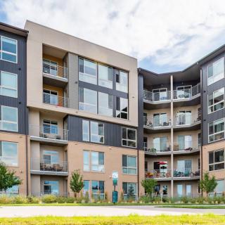 A modern apartment building with multiple balconies and large windows.