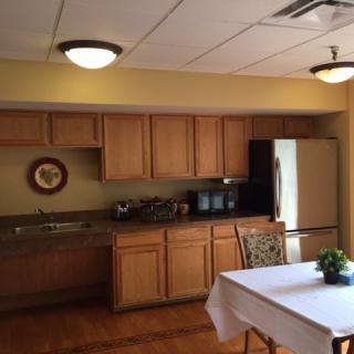 A cozy kitchen and dining area with wooden cabinets and a small table.
