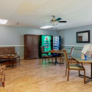 A waiting area with seating, tables, and vending machines.