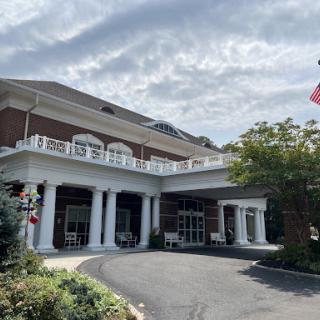 A picturesque view of a hotel entrance featuring classical architecture and a U.S. flag.