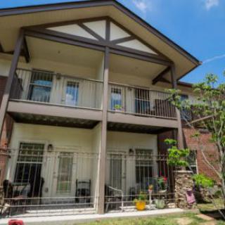 A two-story house with balconies and a garden.