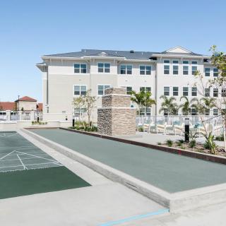 A modern building with an outdoor recreation area featuring a sports court.