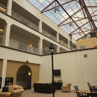 A spacious atrium with a glass ceiling and comfortable seating areas.