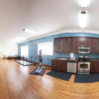 A modern kitchen interior with wooden cabinets, stainless steel appliances, and hardwood floors.