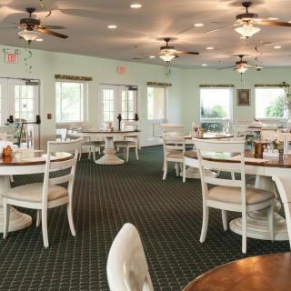 An empty restaurant dining area with neatly arranged tables and chairs.