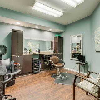 A well-organized hair salon interior with a styling station and comfortable seating.