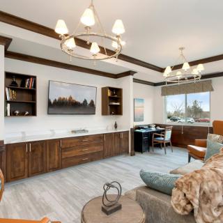 A modern living room with elegant lighting, wooden cabinets, and a large window.