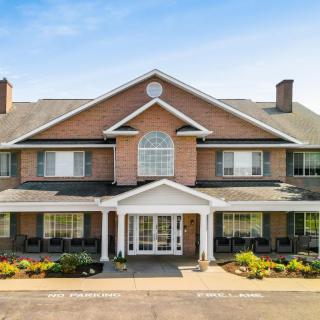 A large brick residential building with a symmetrical facade and well-maintained landscaping.