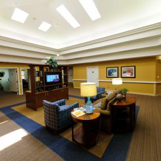 A spacious and well-lit lounge area featuring comfortable seating, a television, and decorative elements.
