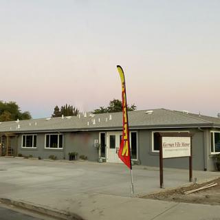 A commercial building with a sign and flag at sunset.