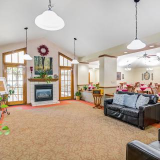 A spacious and cozy living room with a fireplace, comfortable seating, and elegant lighting.
