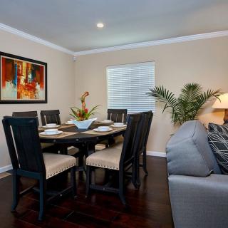 A cozy dining room with a round table, chairs, and decorative artwork on the wall.