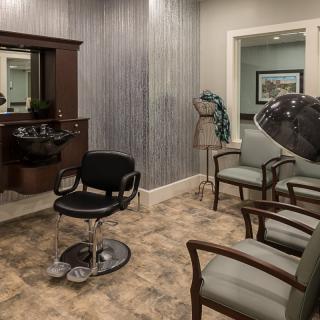 A hair salon interior with seating and hair styling equipment.