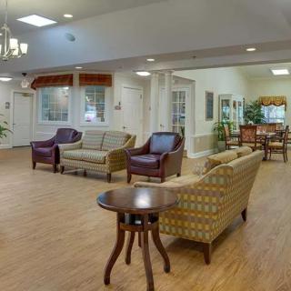 A spacious and elegantly furnished living room with sofas, chairs, and a coffee table.