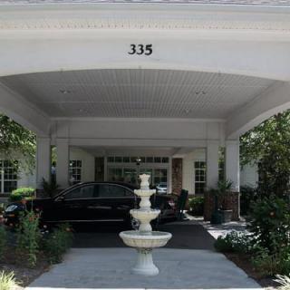 A building entrance with a central fountain and a driveway.