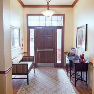 An inviting entrance with a bench and decor, leading to a wooden door.
