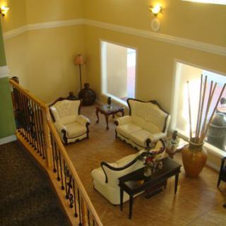 A view of a well-furnished living room with elegant sofas and accent lighting, seen from a staircase.
