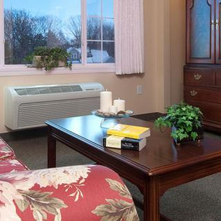 A cozy living room with a floral sofa, coffee table, and various decorative elements.