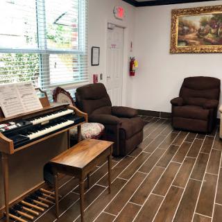 A cozy waiting area featuring comfortable recliners and a keyboard instrument.