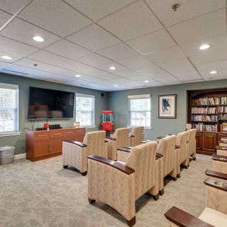 A cozy home theater room with comfortable seating and a large TV.