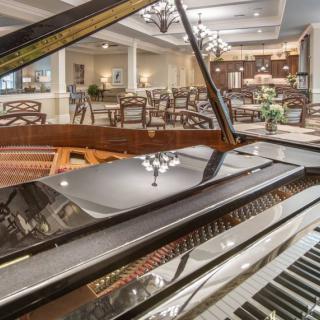 A grand piano in an elegant dining area with a sophisticated ambiance.