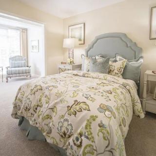 A cozy bedroom with a floral-patterned bedspread and elegant decor.