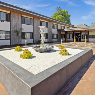 A hotel courtyard with a central fountain and landscaped features.