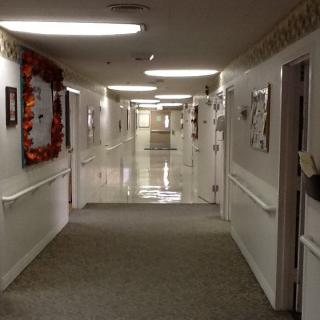 A hospital corridor with doors and bright lighting.