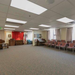 An empty meeting room with rows of chairs and a carpeted floor.