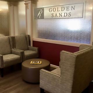 A cozy waiting area with comfortable seating and a sign reading 'Golden Sands'.