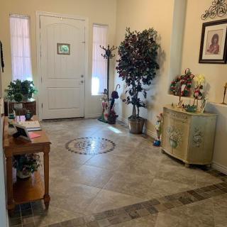 A spacious entryway with decorative furniture and indoor plants.