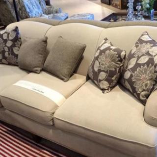 A comfortable beige sofa with patterned and solid cushions arranged in a living room setting.